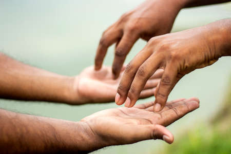 One man puts his hand on the other's hand and blurs the background behind itの写真素材