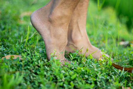 The two legs of the man are styled on grass and blur the background behind itの写真素材