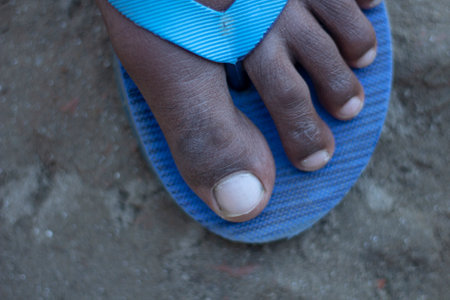 a man keep his own leg on a sandle and the sandle colour is blueの写真素材