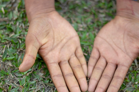 there are two man keep their own hand on the green grass and the background is blurred