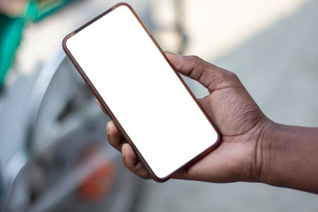 A man is holding a mobile phone in his hand and the mobile screen mockup is a white colorの写真素材