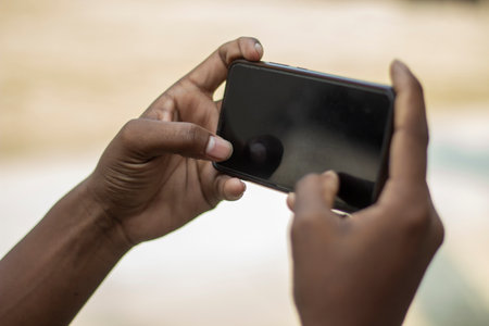 A man is holding a mobile phone in his hand and the mobile screen mockup is a black colorの写真素材