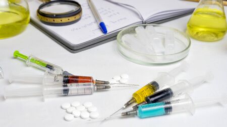 Medical, chemistry or pharmacy background. Laboratory table with various chemical reagents,...
