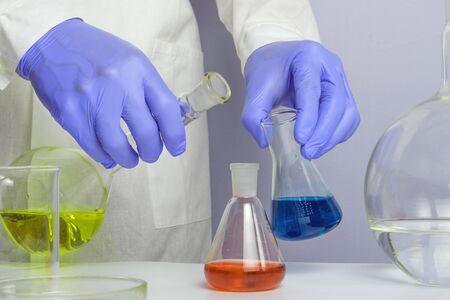 test tubes and hand in laboratory isolated on whiteの写真素材