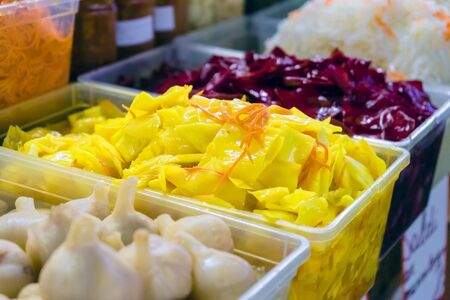 Colorful pickled vegetables. Salting various vegetables in containers for sale. Market. A variety of green vegetables on the table.の写真素材