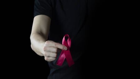 Photo Male hand holding red AIDS awareness ribbon. Aids awareness, World Aids Day, Healthcare and...