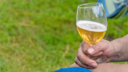 mans hand take apple cider in a glass. Camping.の写真素材