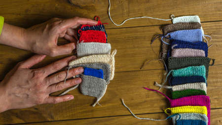 Close up of female hands holding colorful knitted fabric samples
