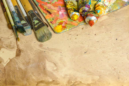 Photo tubes of multicolor oil paint and artist's brushes on canvas close-upの写真素材