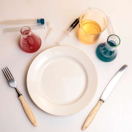 Photo a plate with a spoon and fork in the laboratory. Diet concept with chemicals.の写真素材