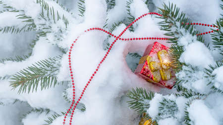 Top view Christmas decoration in the form of a gift on a spruce branch covered with natural snow. Winter christmas pictureの写真素材
