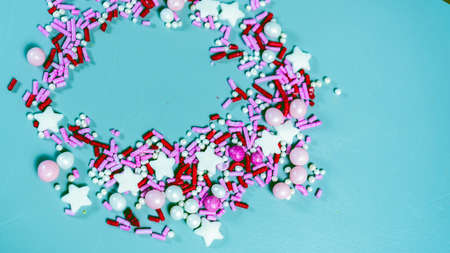 Photo Colorful candy sprinkles isolated on blue background card