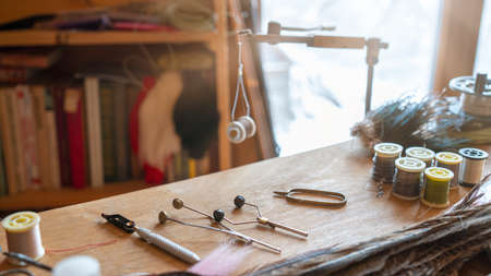 Photo Fishing fly tying materials and tools on a wooden tableの写真素材