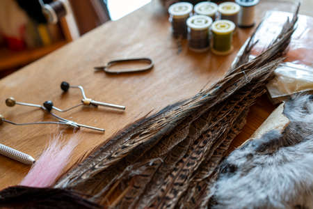 Materials and tools for tying lures on a wooden table. Fly Fishing Still Life.の写真素材