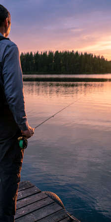 Fly fishing summer fishing in a mountain river. Beautiful nature, forest and sunset.の写真素材