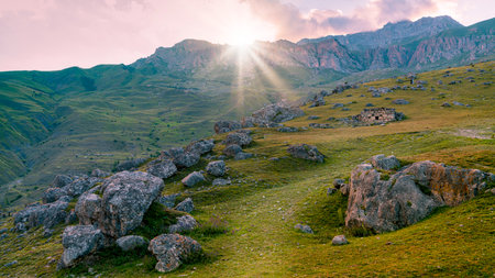 Photo Sun rays breaking through the mountain at sunset.の写真素材