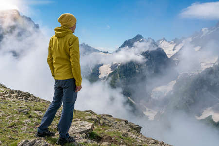 Photo Tourist on the peak of high rocks. Sport and active life conceptの写真素材