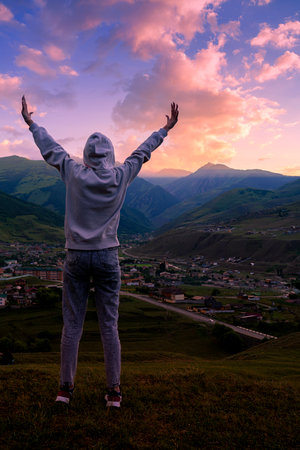 The young woman feels strong and confident. Against the backdrop of a beautiful mountain landscape....