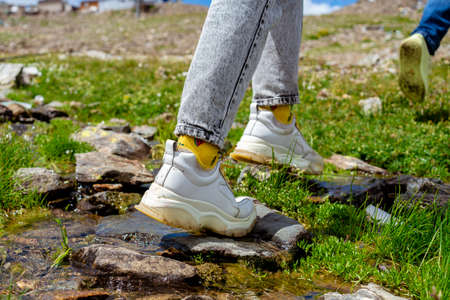Young woman hiker legs walking on trail in spring mountains. Close up.