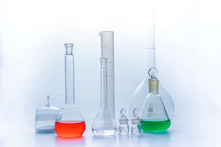 Photo Laboratory glass flasks with multicolored liquid isolated on whiteの写真素材