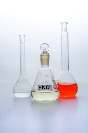 Photo Laboratory glass flasks with multicolored liquid isolated on whiteの写真素材