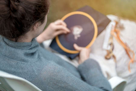 Home needlework concept, ross-stitched pillow in female hands.の写真素材
