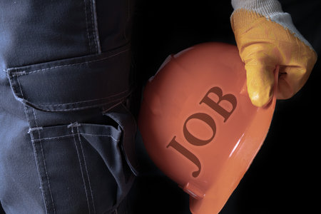 I offer a job to a handyman. In his hand he has a construction helmet with the description JOB....