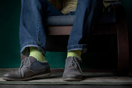 Legs of a business man in elegant clothes, yellow silk socks and shoes