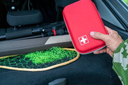 A man holds a first aid kit in his hands in a car, close-up.の写真素材