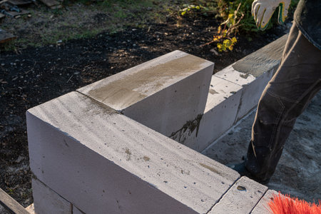 bricklayer builder working with autoclaved aerated concrete blocks. Walling, installing bricks on construction site, Engineering and constructions concepts.の写真素材