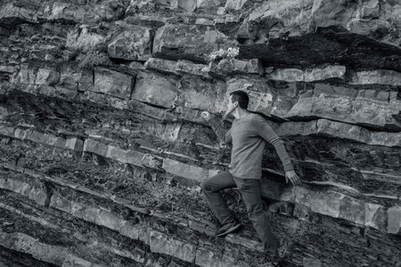 Man in a knitted sweater against a rock background