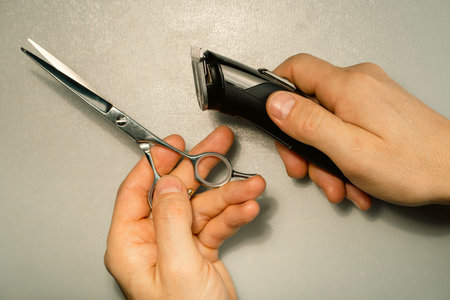 Hairdresser's hands holding hair cutting tools on white background.の写真素材