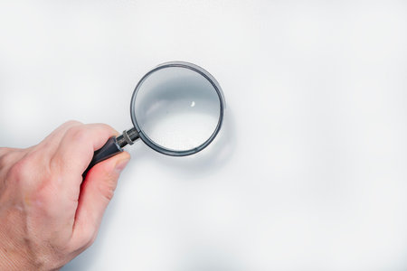 Hand holding magnifier tool isolated on white background. discover and research concept.の写真素材
