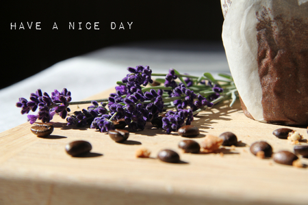 Chocolate muffin on a wooden cutting boar with roasted coffee beans and lavender with a nice day signの写真素材