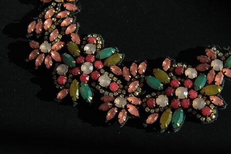A colorful modern necklaces in shape of flowers isolated on black backgroundの写真素材