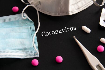 Novel Coronavirus 2019-nCoV outbreak concept. Coronavirus protective breathing mask with pills, and cornavirus title selective focusの写真素材