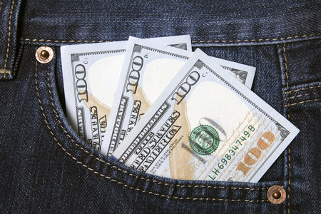 dollars invested in a pocket of dark jeans closeupの写真素材