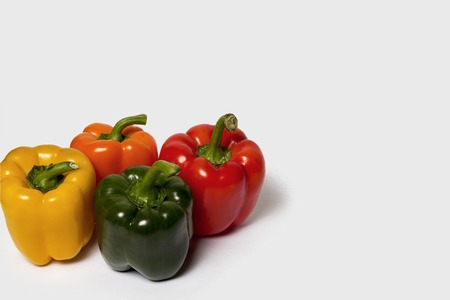 Red green and orange sweet bell peppers isolated on white background
