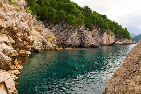 The rock is surrounded by water and sea waves beating against the rock. Adriatic sea is color blue. Nature of Montenegroの写真素材