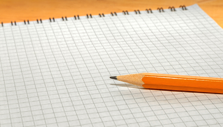 Pencil and an open notebook on a wooden background close upの写真素材