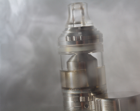 An electronic cigarette in the clouds of steam