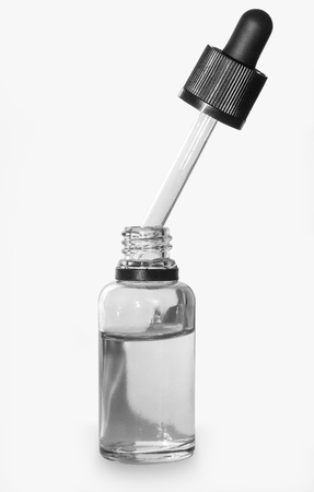 Glass bottle with pipette close up isolated on a light backgroundの写真素材