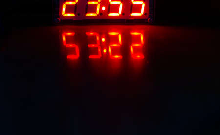 Reflection of an electronic clock on a dark backgroundの写真素材