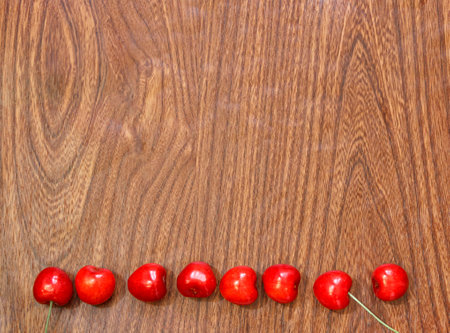 Frame of ripe cherries on a wooden background