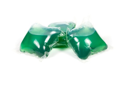 Green washing capsules on white backgroundの写真素材