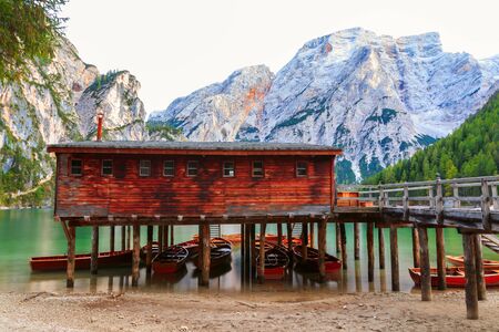 Old wooden house on the Braies lake in the background of Seekofel mountain in Dolomites,Italy ( Pragser Wildsee )のeditorial素材