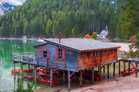 Old wooden house on the Braies lake in the background of Seekofel mountain in Dolomites,Italy ( Pragser Wildsee )のeditorial素材