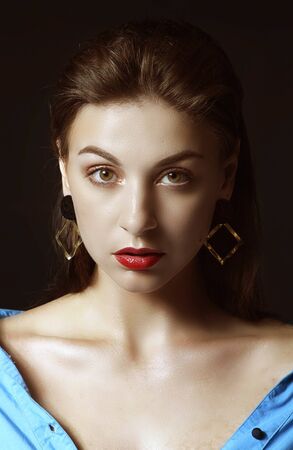 Glamour portrait of beautiful woman model brunette with fresh daily makeup. Fashion shiny highlighter on skin, sexy gloss lips make-up and dark eyebrows.の写真素材
