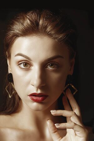 Glamour portrait of beautiful woman model brunette with fresh daily makeup. Fashion shiny highlighter on skin, sexy gloss lips make-up and dark eyebrows.の写真素材