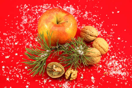 Christmas decoration - walnuts and apple on redの写真素材